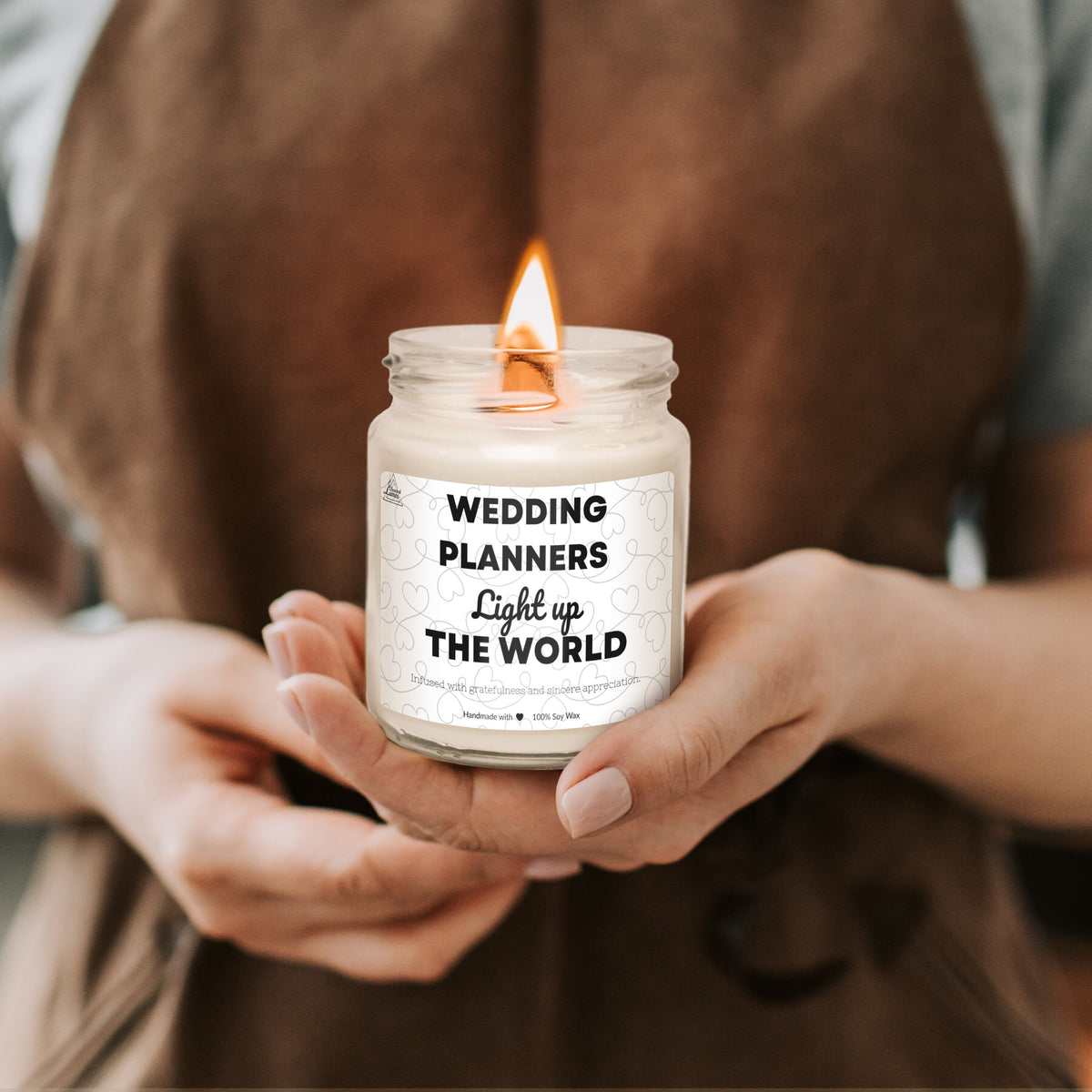 a person holding a candle that says wedding planners light up the world
